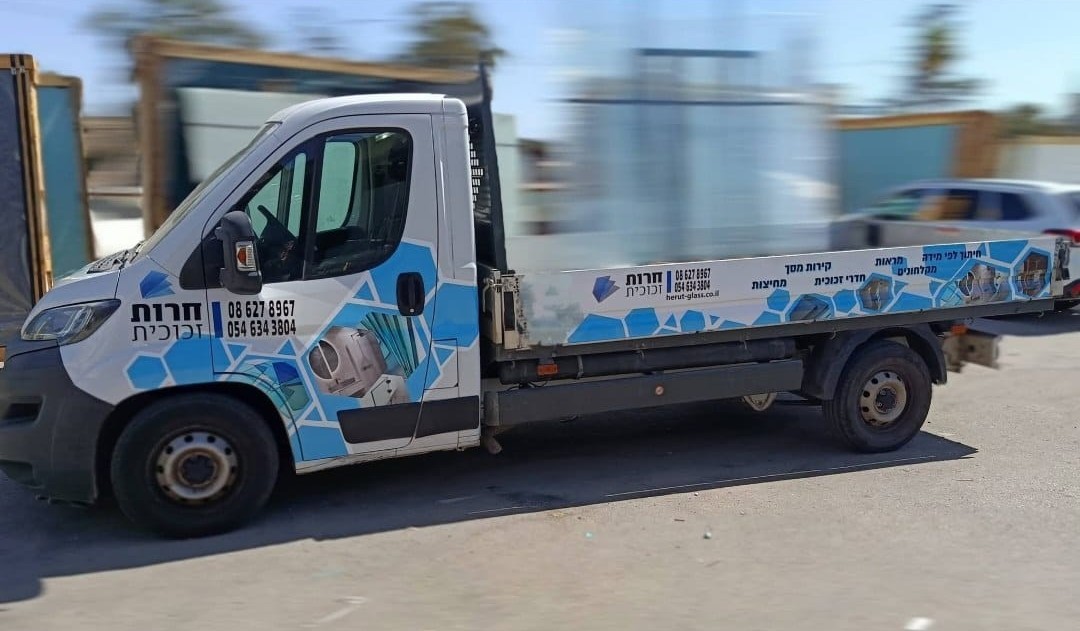 Blue and white graphics across the cab and sides of a delivery truck.